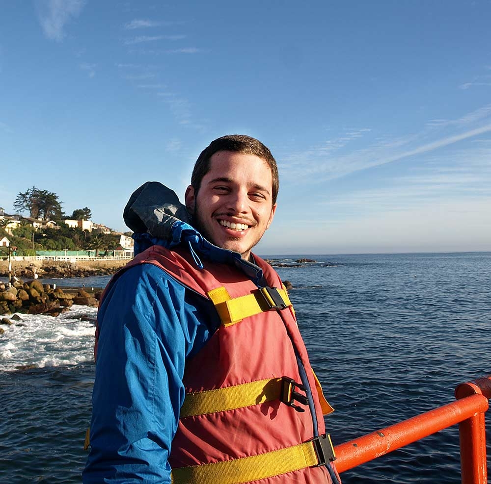 Daniel Viana wears life jacket riding a boat