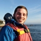 Daniel Viana wears life jacket riding a boat